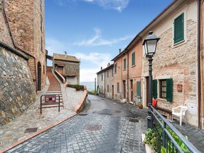 A narrow cobblestone street flanked by historic stone buildings with traditional shutters and a staircase leading to a building with a tiled roof. - Holiday Home in Ficulle With Pool Access (Ficulle)