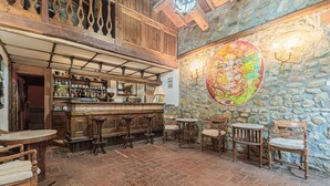 A rustic bar area with wooden furniture, a stone wall, and a large map mural. - Holiday Home in Ficulle With Pool Access (Ficulle)