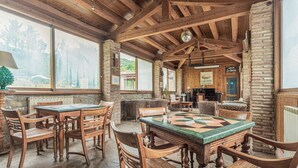 A rustic interior with wooden furniture, stone walls, and large windows offering a view of the forest. - Holiday Home in Ficulle With Pool Access (Ficulle)