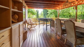 A wooden deck with a table and chairs, surrounded by greenery. - Pleasing Chalet in Stegeren near Forest (Stegeren)