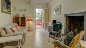 A living room with a sofa, armchairs, a fireplace, and a bookshelf. - Villa With Garden Near Versilia Beach (Camaiore)