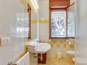 A bathroom with a sink, mirror, and toilet.