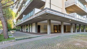 Ein modernes Gebäude mit überdachter Eingangspartei, Sitzgelegenheiten im Freien und einem gepflasterten Innenhof.