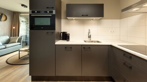 Een moderne keuken met een ingebouwde oven, een koffiezetapparaat en een spoelbak.