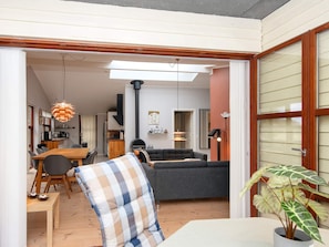 Un salon moderne avec un canapé, une table à manger et des chaises, et un coin cuisine à l’arrière-plan.