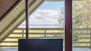 En tv-apparat i ett rum med utsikt över en sjö och träd.