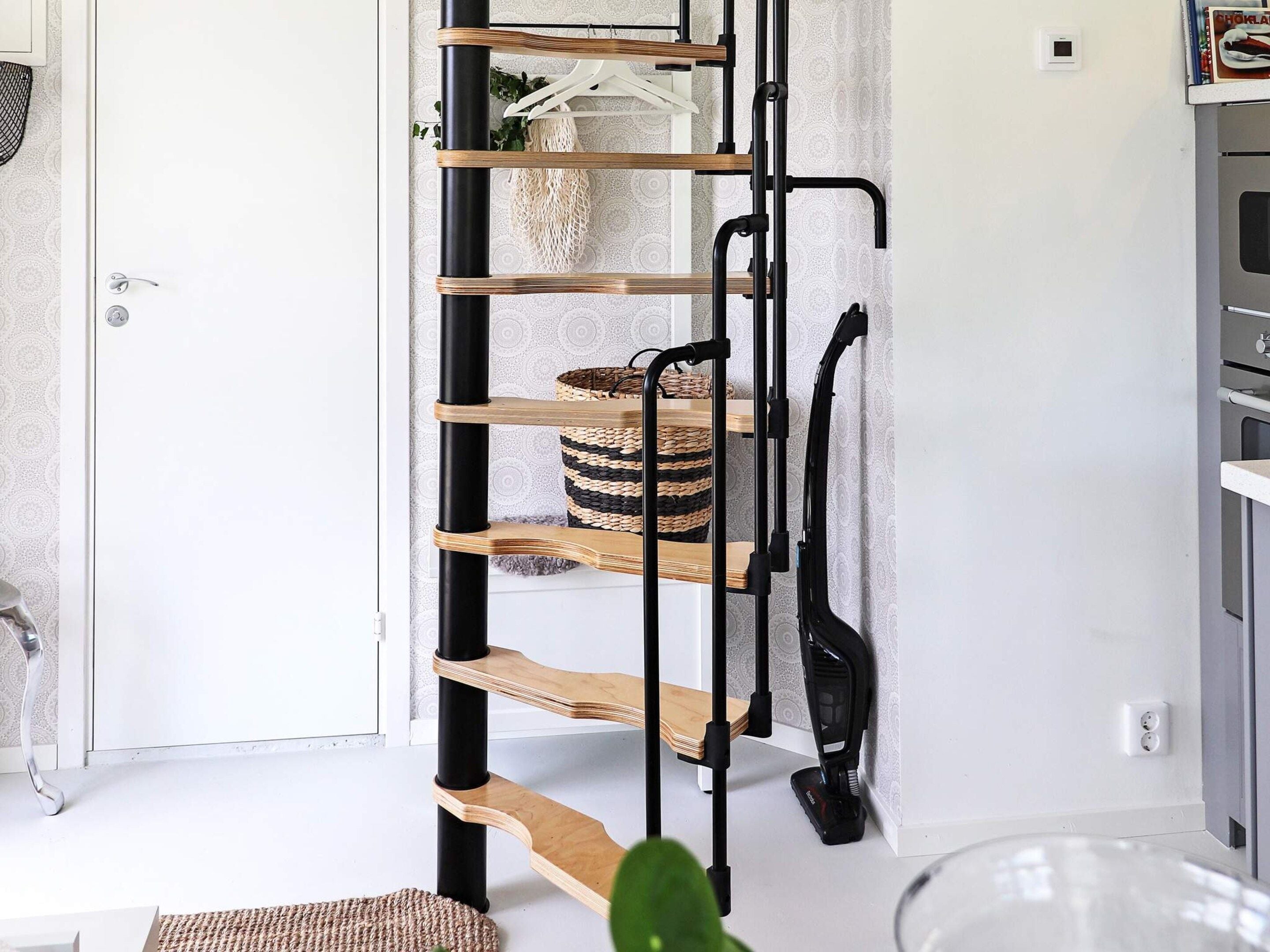 A modern interior with a black metal staircase, wooden shelves, and a basket.