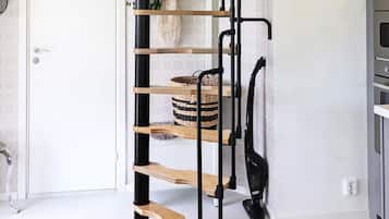A modern interior with a black metal staircase, wooden shelves, and a basket.