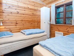 A cabin with two beds, a white wardrobe, and a window with curtains. - 4 Star Holiday Home in Ebeltoft (Ebeltoft)