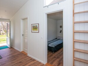 A room with a bed, a door, and a wall-mounted shelf. - Holiday Home in Silkeborg (Silkeborg)