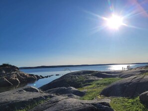 Eine felsige Küste mit klarem Himmel und ruhigem Wasser.