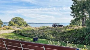 A bench overlooking a scenic view with a car parked in the distance. - 7 Person Holiday Home in Hakenaset (Hakenäset)