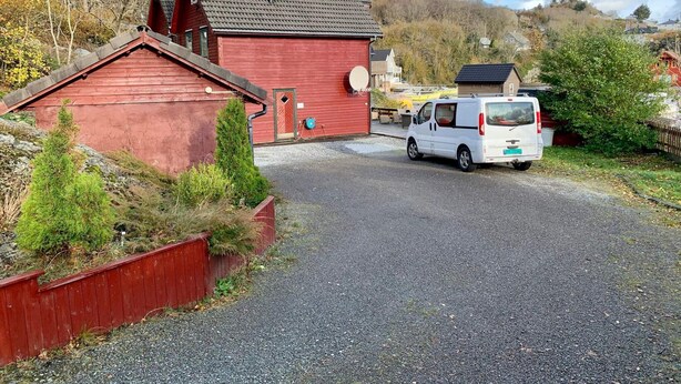 A red building with a gravel driveway and a white van parked in front. - 6 Person Holiday Home in Bomlo (Bomlo)
