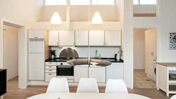 A modern kitchen with white cabinets, a central island, and pendant lighting.