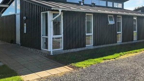 A modern building with a dark exterior, large windows, and a sloped roof. - Holiday Home in Bogense (Bogense)