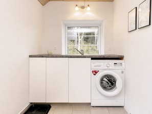 A laundry room with a washing machine, a window, and a countertop. - Holiday Home in LÃ¸kken (Lokken)