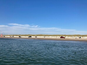 A beach with caravans and a lighthouse in the background. - Holiday Home in LÃ¸kken (Lokken)