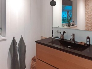 A modern bathroom with a black countertop sink, a mirror above it, and a wooden cabinet below. - Holiday Home in Solrød Strand (Solrod Strand)