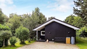 A black building with a sloped roof and a small porch. - Holiday Home in Vejby (Vejby)