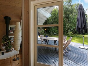 A wooden interior with a view of an outdoor deck and patio furniture. - Holiday Home in Vejby (Vejby)