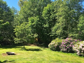 A lush garden with a variety of trees and flowering shrubs. - Holiday Home in Vejby (Vejby)