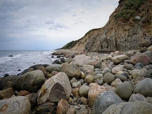 A rocky beach with large boulders and a cliff. - Holiday Home in Vejby (Vejby)