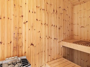 Un sauna avec des murs et des bancs en bois.