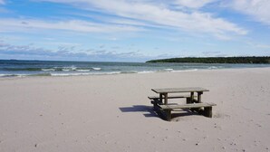 A beach with a wooden picnic table.