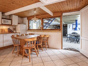 Un interior de madera con cocina, mesa y sillas.