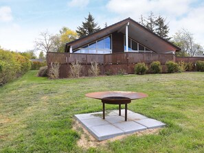 A house with a sloped roof, large windows, and a fenced backyard. - Holiday Home in Skals (Skals)