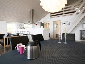 A modern interior with a dining table, chairs, a coffee pot, and a candle on the table. - Holiday Home in Skals (Skals)