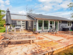 Ett hus med en stor veranda, en inglasad uteplats och ett vinterträdgård.