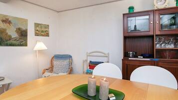 A dining area with a wooden table, three candles, and a green tray.