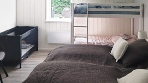 Kerrossänky, jossa on tikkaat, sekä työpöytä ja tuoli huoneessa, jossa on ikkuna.