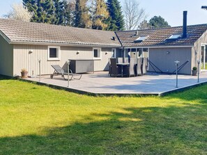 A residential building with a patio area, outdoor furniture, and a chimney. - Holiday Home in VÃ¦ggerlÃ¸se (Vaeggerlose)