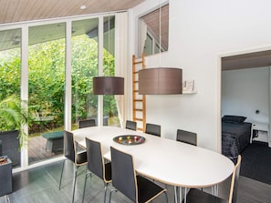 Un espace repas moderne avec une grande table, des chaises et une lampe.