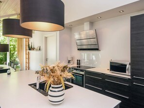 A modern kitchen with a central island, stainless steel appliances, and pendant lighting.