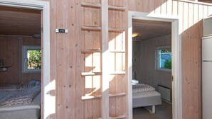 A wooden interior with two bedrooms, each with a window and a bed. A wooden ladder is visible in the center. - 8 Person Holiday Home in Ebeltoft (Ebeltoft)