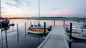 A calm waterfront with a dock and several boats moored at the pier. - Cozy Coastal Cottage at Jegindo-by Traum (Thyholm)