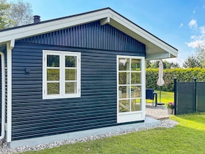 A dark blue house with two windows and a covered patio area.