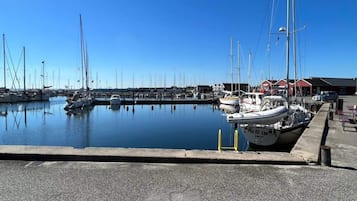 A marina with boats docked, a clear sky, and a building in the background.