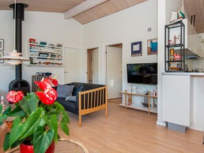 A modern living room with a sofa, a fireplace, and a television.