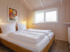 A room with a bed, a painting on the wall, and a window. - Holiday Home in GrÃ¶mmitz (Groemitz)