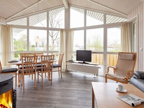 A cozy living room with a fireplace, a dining area, and a comfortable seating area with a television.