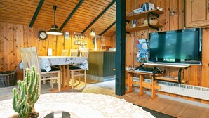 A cozy cabin interior with a dining area, a television, and a cactus plant. - 6 Person Holiday Home in Lokken (Lokken)