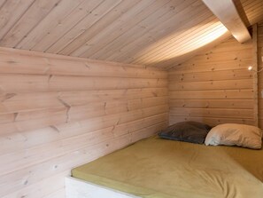 A small, single-bed cabin with wooden walls and a sloped ceiling. - 4 Star Holiday Home in Norre Nebel (Norre Nebel)