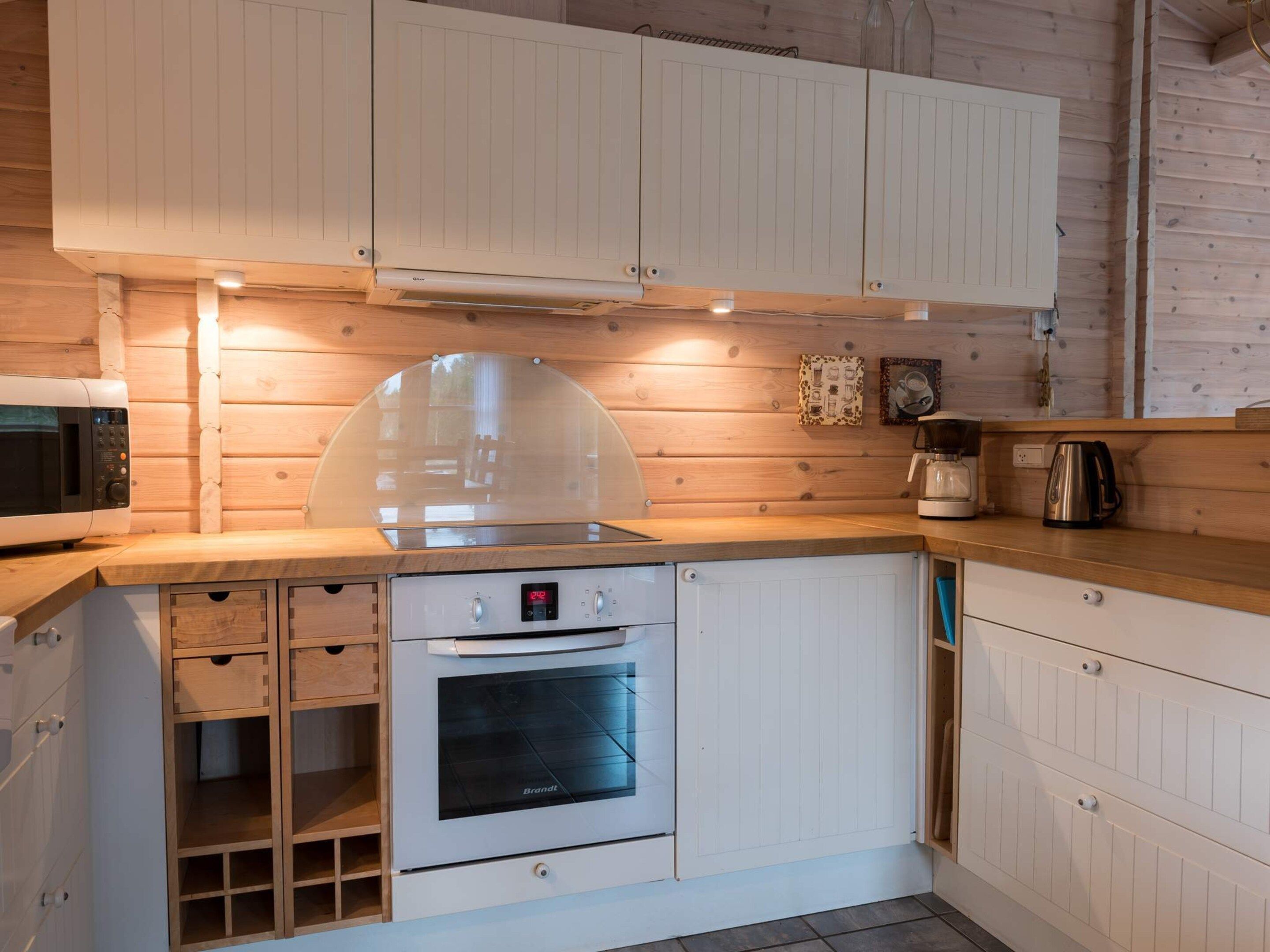 A compact kitchen with a built-in oven, a microwave, and a coffee maker.