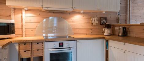 A compact kitchen with a built-in oven, a microwave, and a coffee maker.