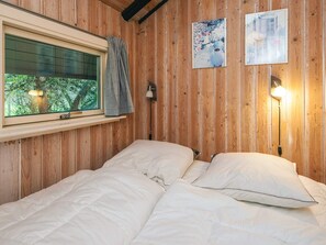 A room with a bed, a window with curtains, and two wall-mounted lamps. - 4 Star Holiday Home in Fano (Fano)