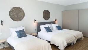Ein Hotelzimmer mit zwei Betten, einem Kleiderschrank und einem Deckenventilator.